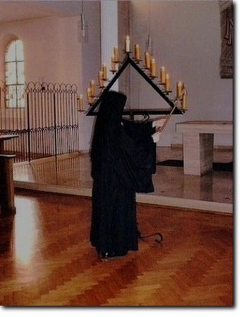 Sr. Bernadette wÃ¤hrend der Karliturgie lÃ¶scht eine Kerze an der Triangelim Kloster der Benediktinerinnen vom Heiligsten Sakrament OsnabrÃ¼ck.  
